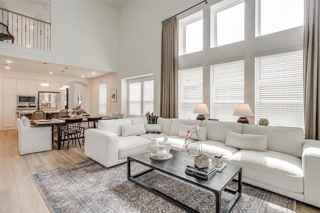 1512 Trailblazer Way, Northlake, TX 76247 - living area featuring arched walkways, a high ceiling, and light wood finished floors