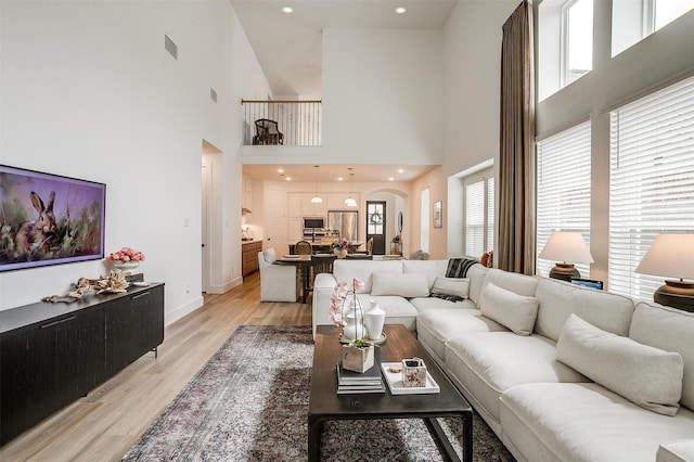 1512 Trailblazer Way, Northlake, TX 76247 - living area with light wood-style flooring, a high ceiling, arched walkways, and baseboards