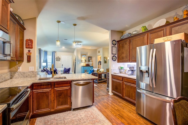 4036 Eagle Dr, Forney, TX 75126 - kitchen featuring open floor plan, stainless steel appliances, a sink, light wood-style floors, and a peninsula