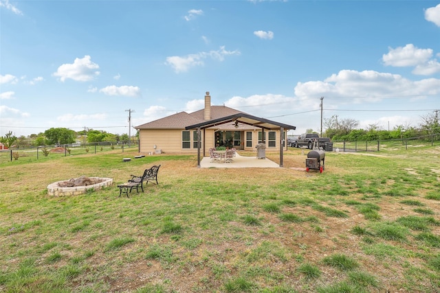 7203 Veal Station Rd, Weatherford, TX 76085 - back of property featuring a patio area, an outdoor fire pit, a chimney, a fenced backyard, and a lawn