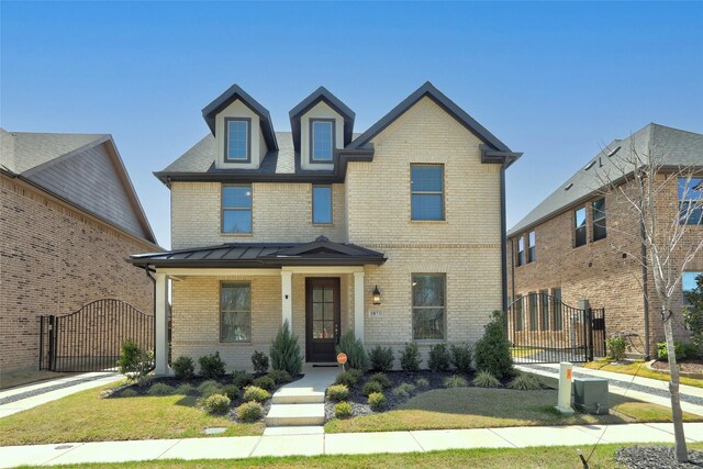 1873 Lakemont Dr, Van Alstyne, TX 75495 - view of front of house with metal roof, a gate, a standing seam roof, and brick siding