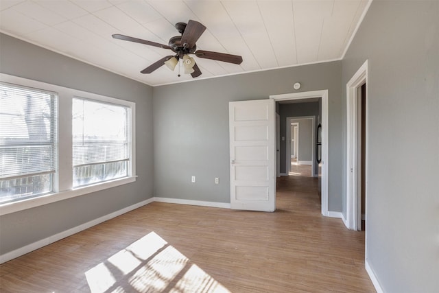 unfurnished bedroom with baseboards, light wood-type flooring, ceiling fan, and ornamental molding