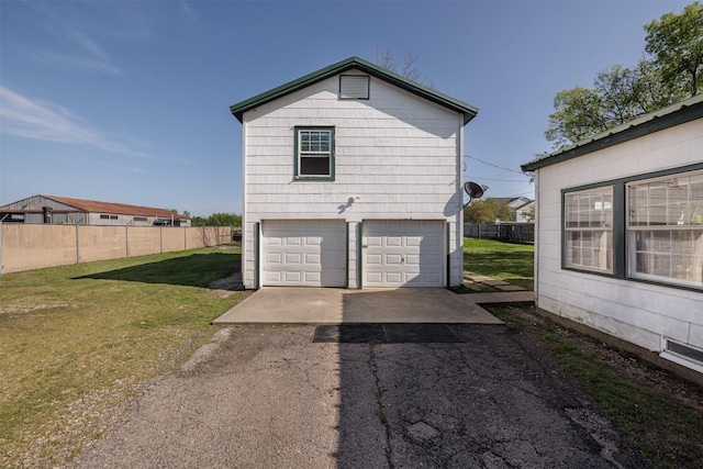 view of side of property featuring a lawn, a garage, and fence