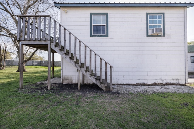 exterior space with stairs, metal roof, fence, and a yard