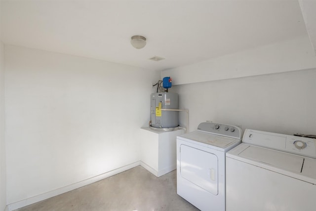 washroom featuring baseboards, gas water heater, separate washer and dryer, and laundry area