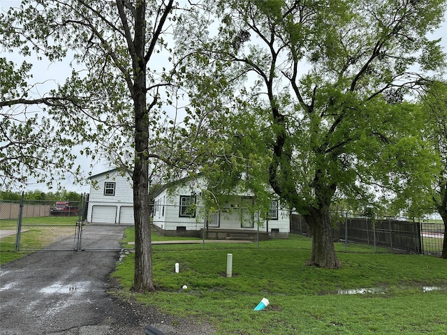 view of front of property with fence, an attached garage, aphalt driveway, a gate, and a front lawn