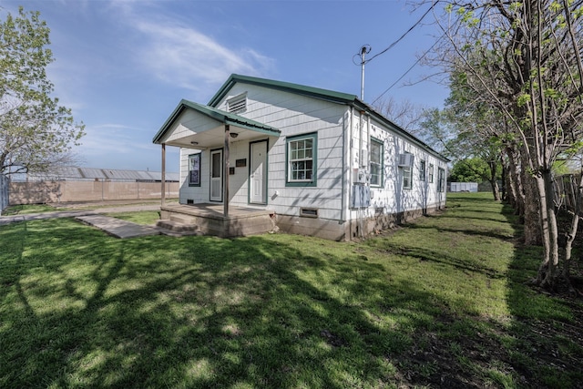 view of front facade featuring crawl space, a front yard, covered porch, and fence