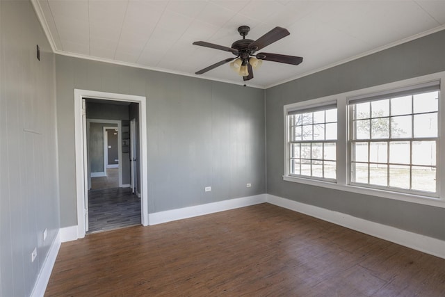 spare room featuring baseboards, dark wood-style floors, ornamental molding, and a ceiling fan