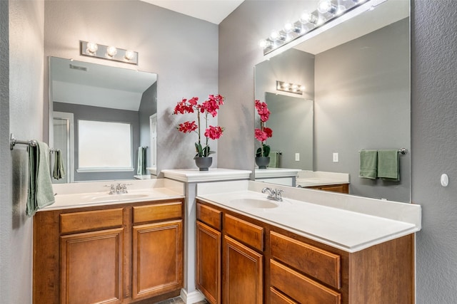 9212 Water Oak Dr, Arlington, TX 76002 - full bathroom featuring two vanities and a textured wall