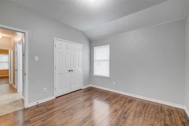 9212 Water Oak Dr, Arlington, TX 76002 - unfurnished bedroom with wood finished floors, vaulted ceiling, baseboards, and a closet