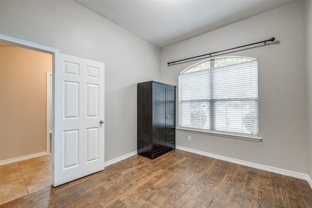 9212 Water Oak Dr, Arlington, TX 76002 - unfurnished bedroom featuring wood finished floors, baseboards, and vaulted ceiling