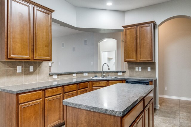9212 Water Oak Dr, Arlington, TX 76002 - kitchen with a sink, arched walkways, backsplash, brown cabinets, and a kitchen island