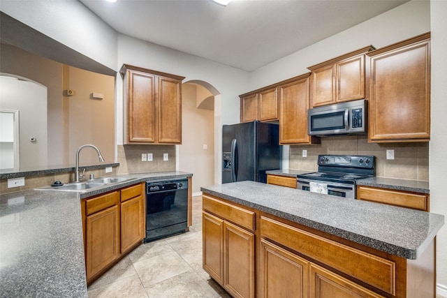 9212 Water Oak Dr, Arlington, TX 76002 - kitchen with black appliances, a sink, arched walkways, and tasteful backsplash