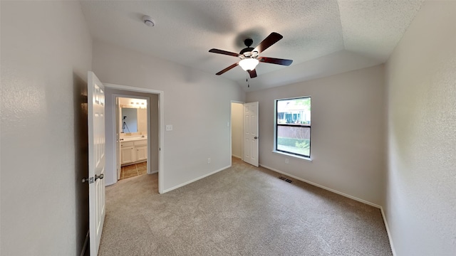 unfurnished bedroom with vaulted ceiling, light carpet, a textured ceiling, baseboards, and visible vents