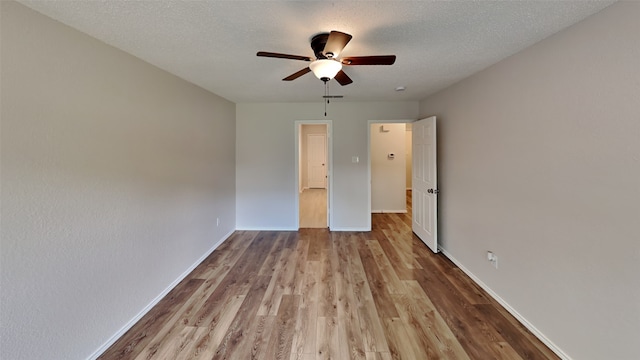 unfurnished bedroom with baseboards, a ceiling fan, wood finished floors, and a textured ceiling