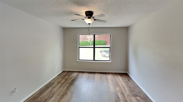 empty room with baseboards, a textured ceiling, ceiling fan, and wood finished floors