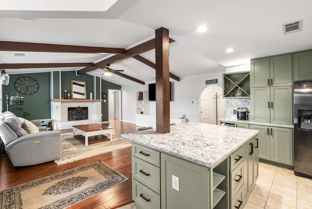 1417 Northridge Dr, Carrollton, TX 75006 - kitchen with stainless steel refrigerator with ice dispenser, green cabinetry, vaulted ceiling with beams, and open shelves