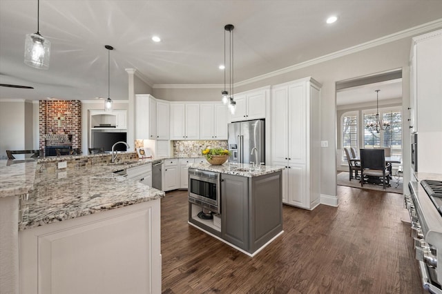 kitchen with dark wood-type flooring, crown molding, a notable chandelier, and appliances with stainless steel finishes