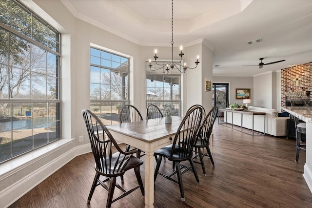 dining space with dark wood-style flooring, a wealth of natural light, and ceiling fan with notable chandelier