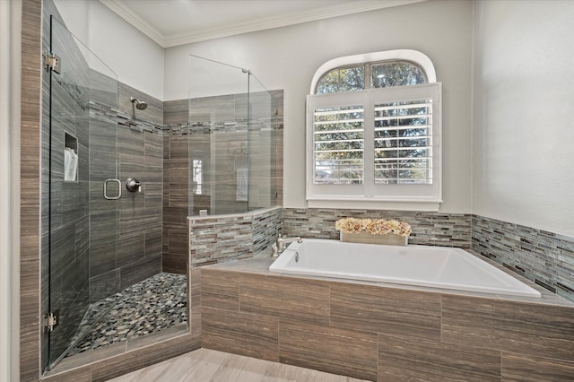 bathroom with a garden tub, crown molding, and a shower stall