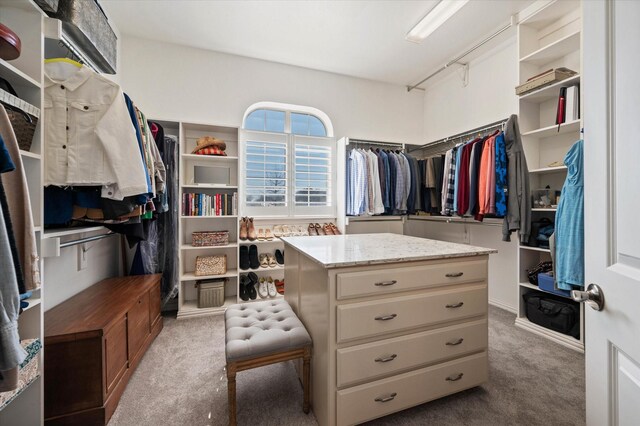 walk in closet with dark carpet