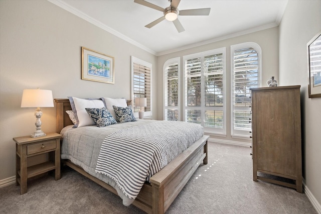 bedroom featuring baseboards, a ceiling fan, crown molding, and light colored carpet