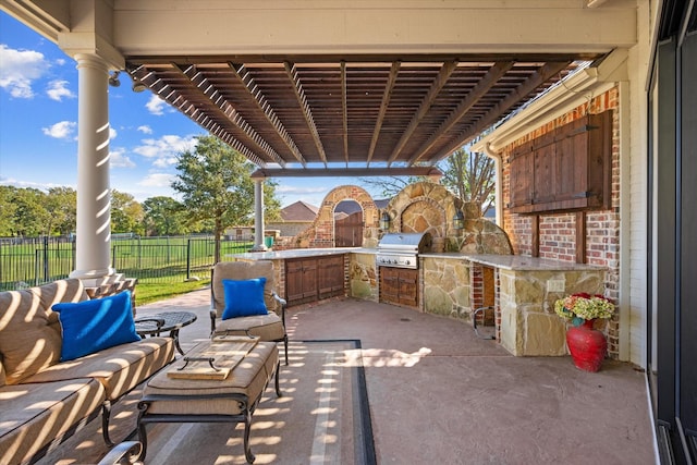 view of patio / terrace with grilling area, a pergola, exterior kitchen, and fence