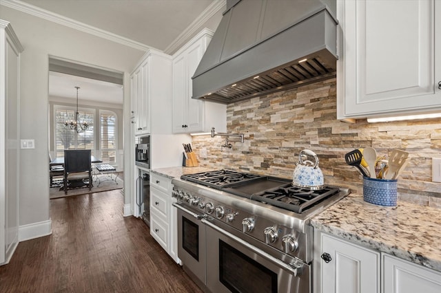kitchen with decorative backsplash, custom exhaust hood, white cabinetry, double oven range, and a notable chandelier