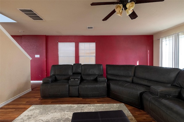living area featuring baseboards, visible vents, a ceiling fan, and wood finished floors
