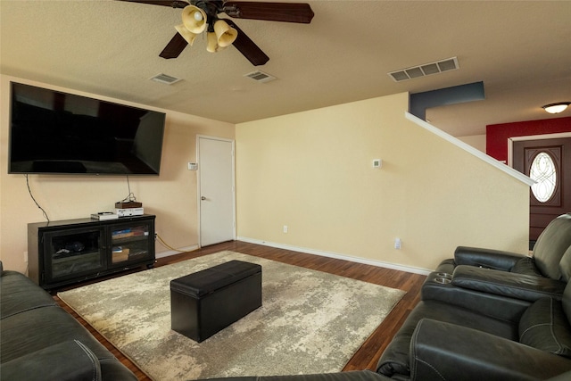 living room with visible vents, a ceiling fan, and wood finished floors