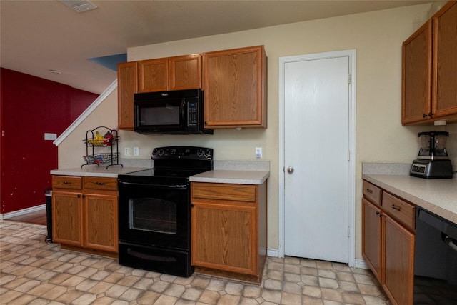 kitchen with brown cabinets, light countertops, black appliances, and visible vents
