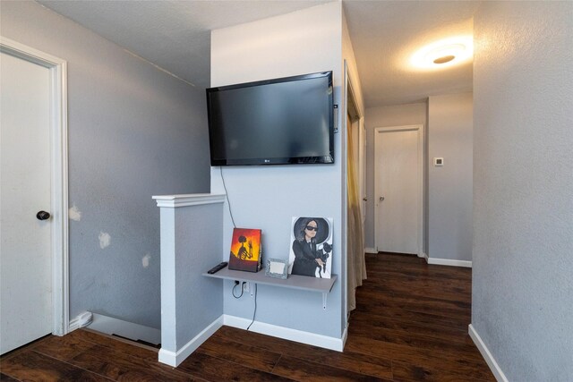 corridor featuring baseboards and wood finished floors