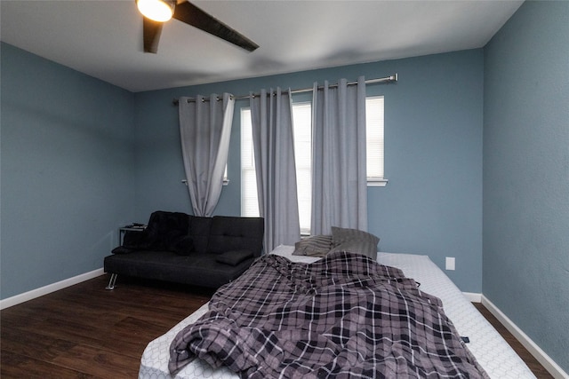 bedroom featuring a ceiling fan, baseboards, and wood finished floors