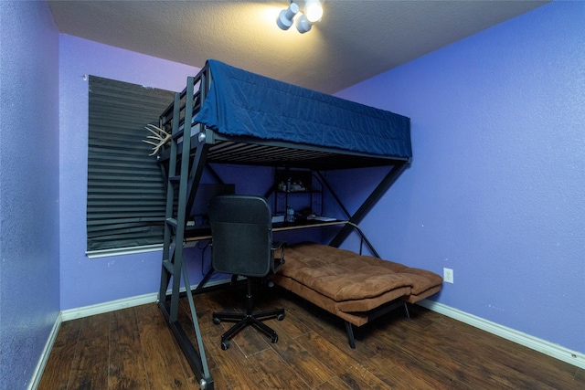 bedroom with baseboards and wood finished floors