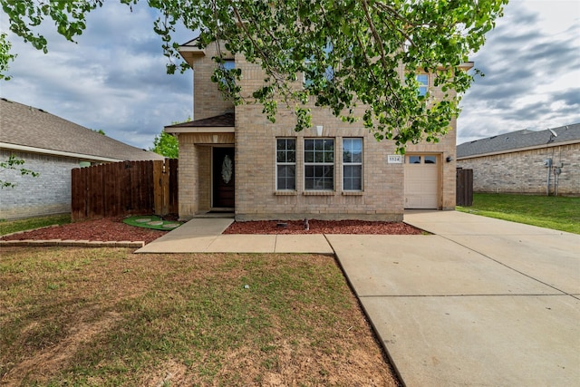 traditional-style house featuring a front yard, concrete driveway, and fence