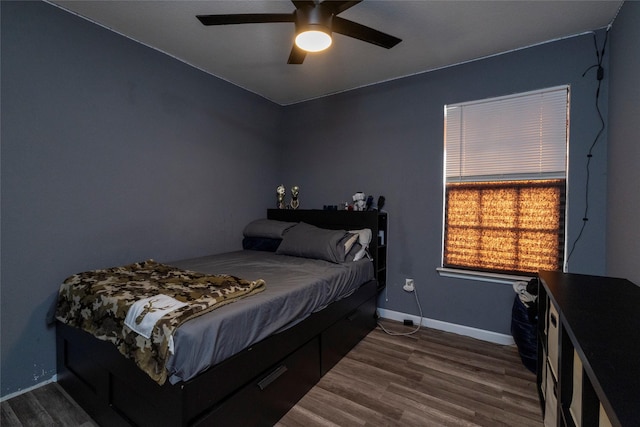 bedroom featuring baseboards, ceiling fan, and dark wood finished floors