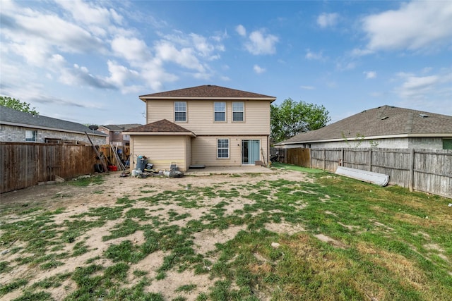 rear view of house with a fenced backyard, a yard, and a patio