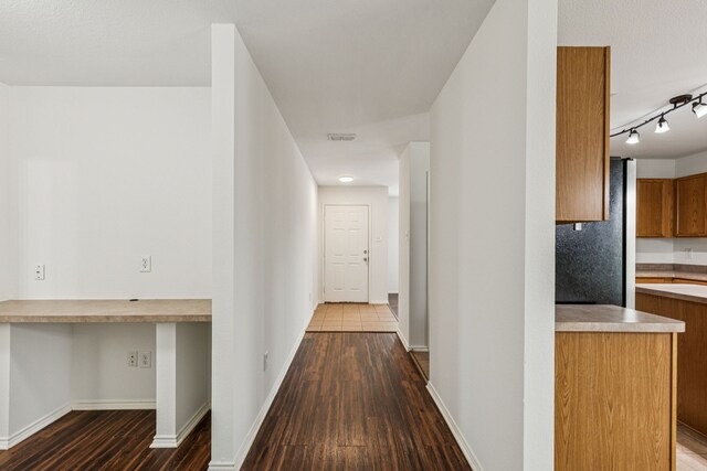 1416 Eagles Nest Trl, Krum, TX 76249 - hallway with dark wood-style flooring, rail lighting, and baseboards