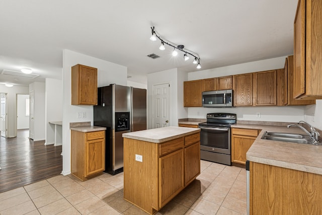 1416 Eagles Nest Trl, Krum, TX 76249 - kitchen featuring appliances with stainless steel finishes, a sink, light countertops, a kitchen island, and light tile patterned flooring