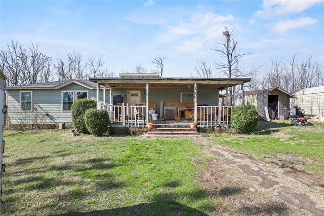 back of house featuring a yard and covered porch