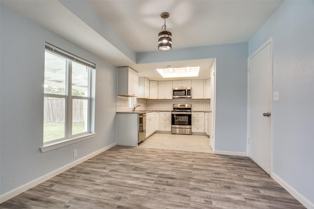 2828 Elk Grove Rd, Carrollton, TX 75007 - kitchen featuring appliances with stainless steel finishes, decorative backsplash, a sink, and light wood-style flooring