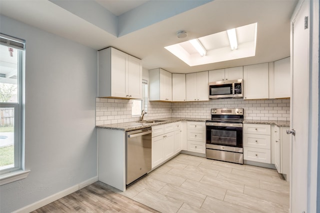 2828 Elk Grove Rd, Carrollton, TX 75007 - kitchen with appliances with stainless steel finishes, plenty of natural light, tasteful backsplash, and light stone countertops