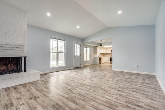 2828 Elk Grove Rd, Carrollton, TX 75007 - unfurnished living room with lofted ceiling, light wood-style floors, a brick fireplace, baseboards, and recessed lighting