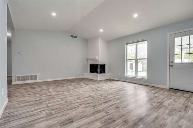2828 Elk Grove Rd, Carrollton, TX 75007 - unfurnished living room with vaulted ceiling, light wood-style flooring, a brick fireplace, baseboards, and recessed lighting
