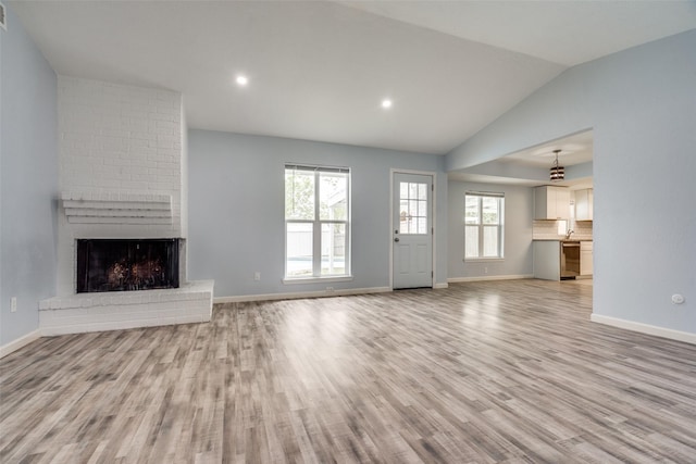 2828 Elk Grove Rd, Carrollton, TX 75007 - unfurnished living room featuring light wood finished floors, lofted ceiling, a fireplace, baseboards, and recessed lighting