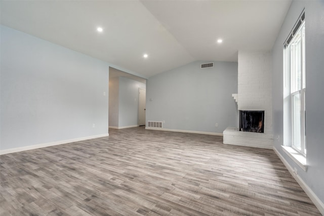 2828 Elk Grove Rd, Carrollton, TX 75007 - unfurnished living room featuring plenty of natural light, lofted ceiling, a fireplace, wood finished floors, and baseboards
