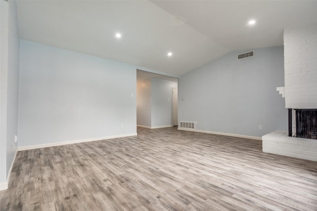 2828 Elk Grove Rd, Carrollton, TX 75007 - unfurnished living room featuring lofted ceiling, wood finished floors, a brick fireplace, recessed lighting, and baseboards