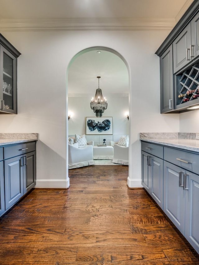 corridor with crown molding, arched walkways, baseboards, and dark wood-style flooring