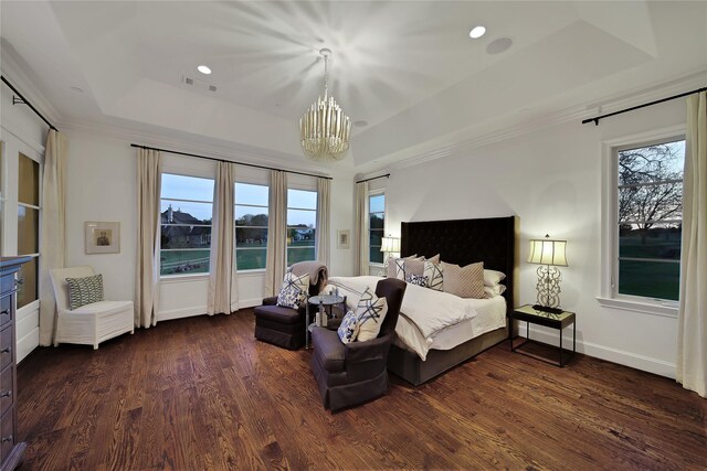 bedroom featuring dark wood-style flooring, a tray ceiling, an inviting chandelier, and visible vents