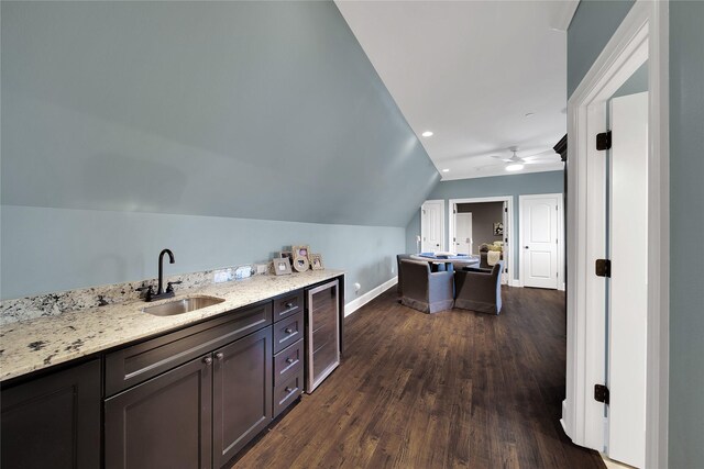 bar featuring lofted ceiling, beverage cooler, baseboards, a sink, and dark wood finished floors